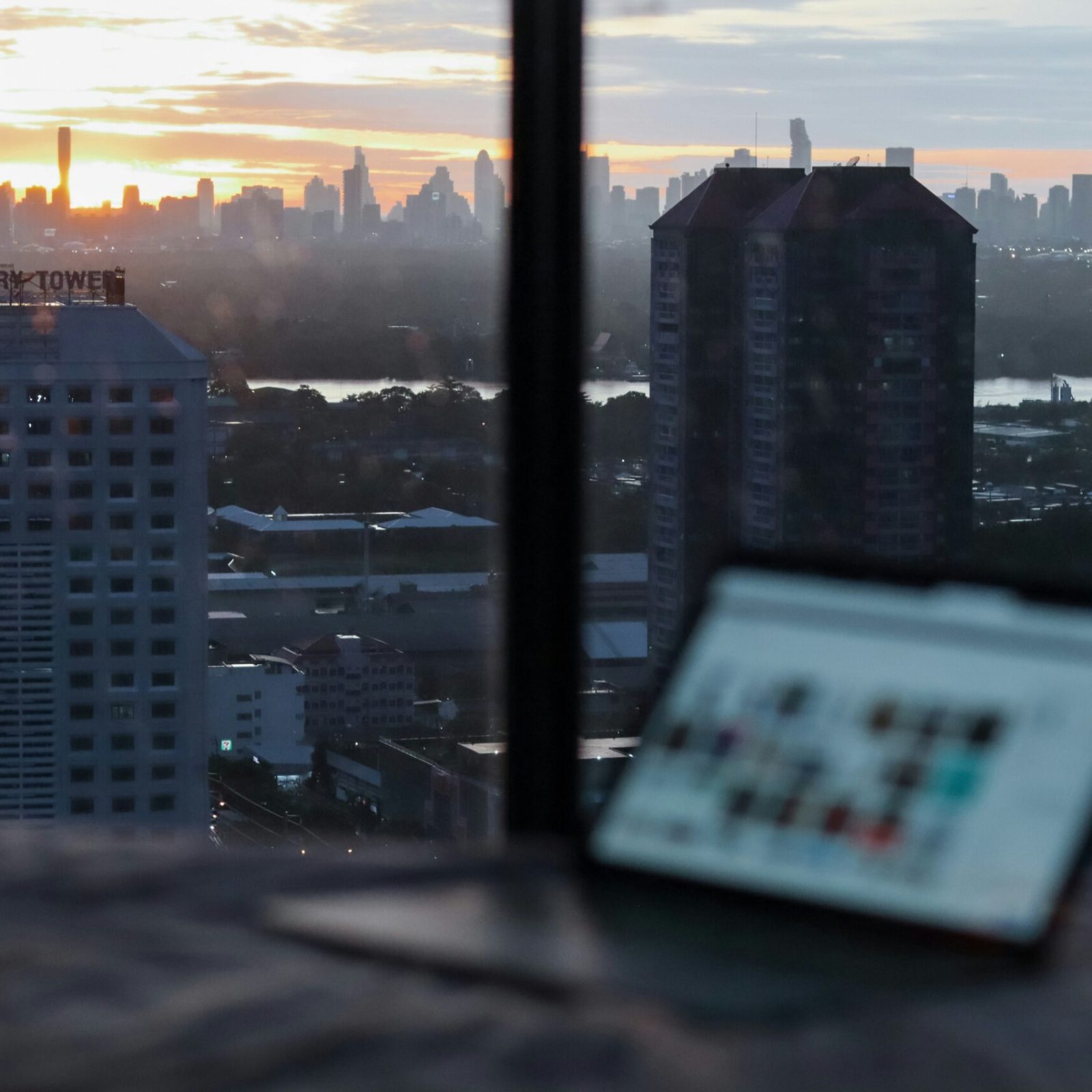 city view through the window with the laptop softly out of focus.